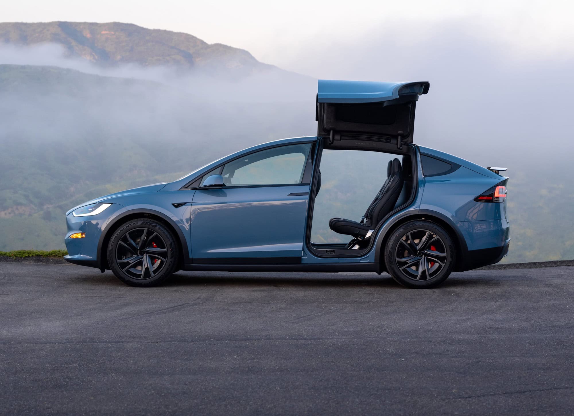 2026 Tesla Model X with the rear falcon wing doors open, showing second row entry