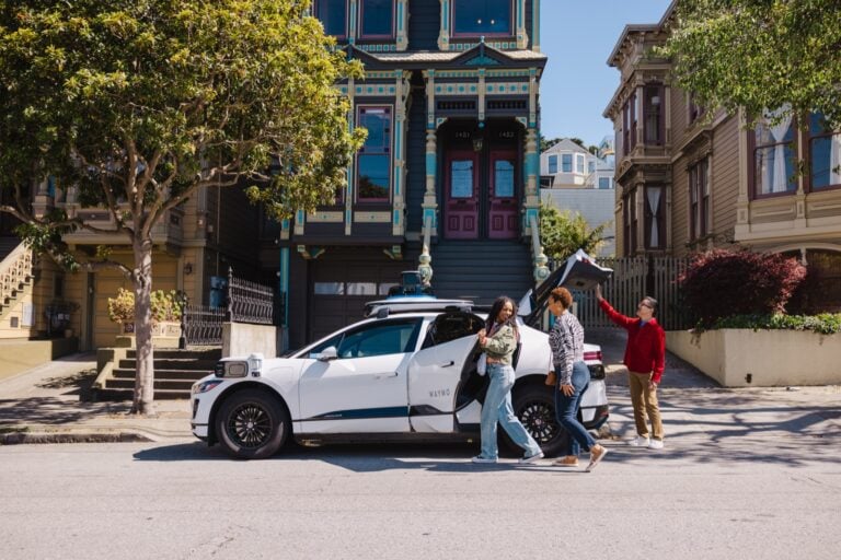 Waymo autonomous Jaguar I-PACE robotaxi picking up riders on a San Francisco street