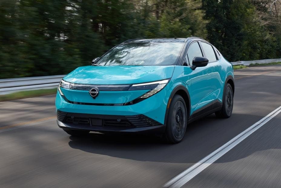 2026 Nissan Leaf in Seabreeze Blue, front three quarter view, driving on a tree lined road