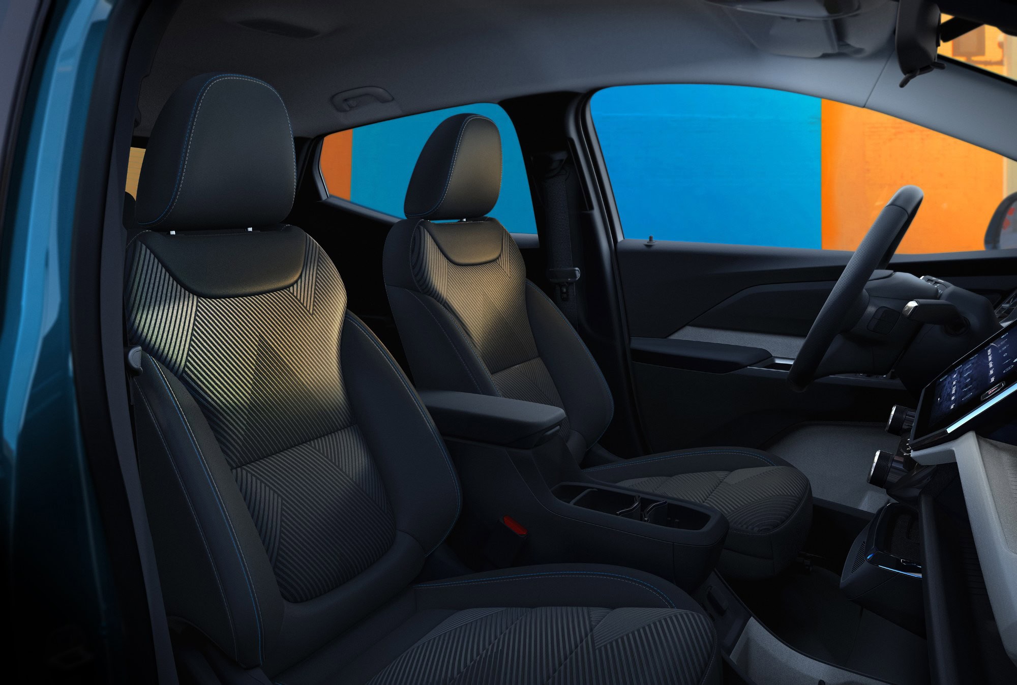 2027 Chevrolet Bolt front seats viewed through the open driver door
