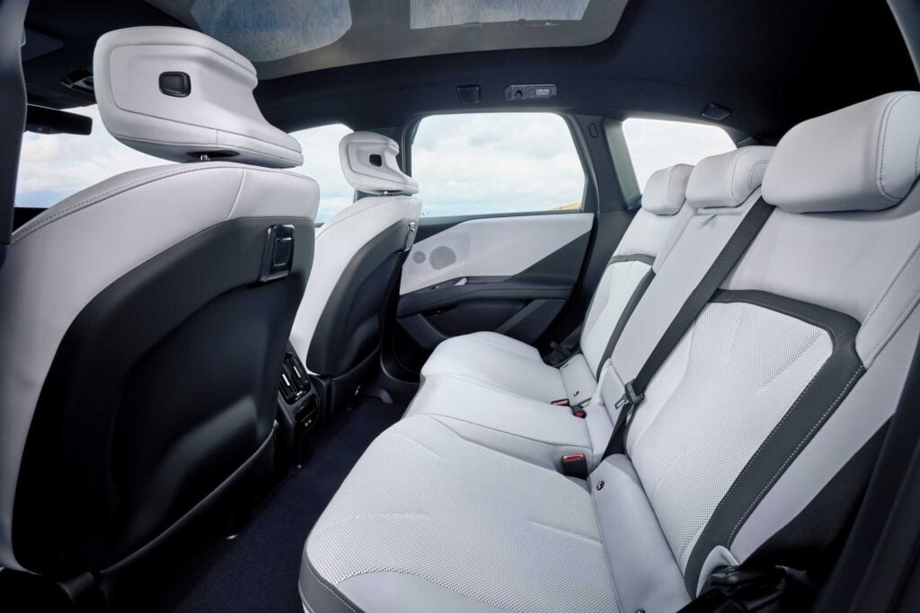 BMW iX3 50 xDrive rear seat in light upholstery under the optional panoramic glass roof, European model shown